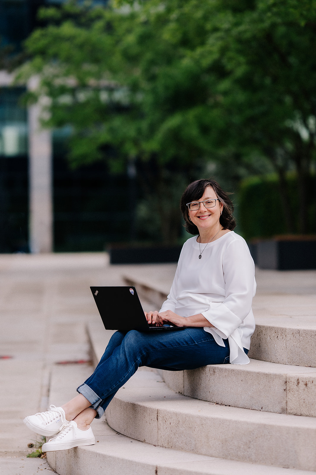 Jana Bodáková working on a laptop on outdoor steps